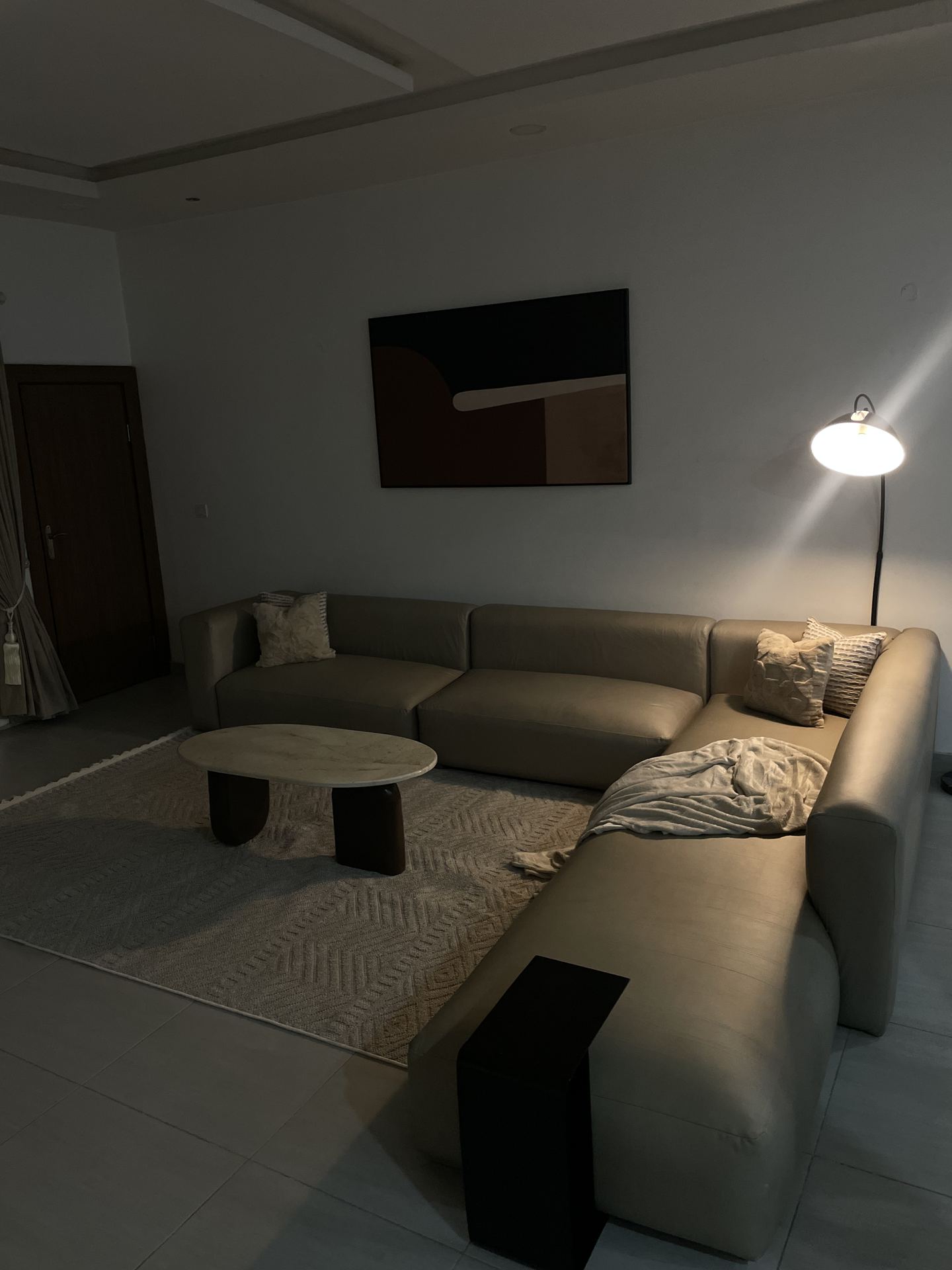 Evening view of the living room lit by an arched floor lamp