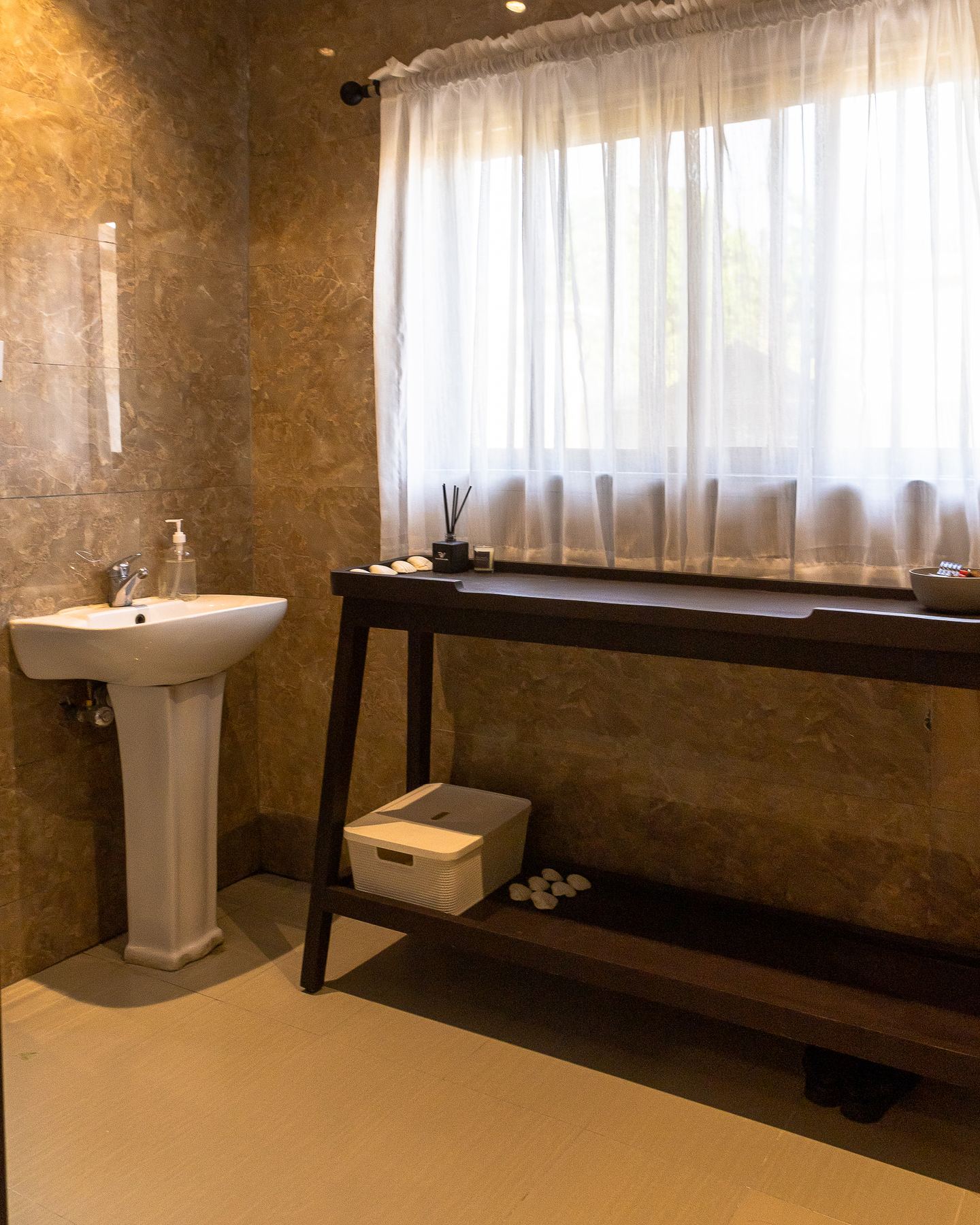 Textured fitting area with a stone-framed mirror and vanity