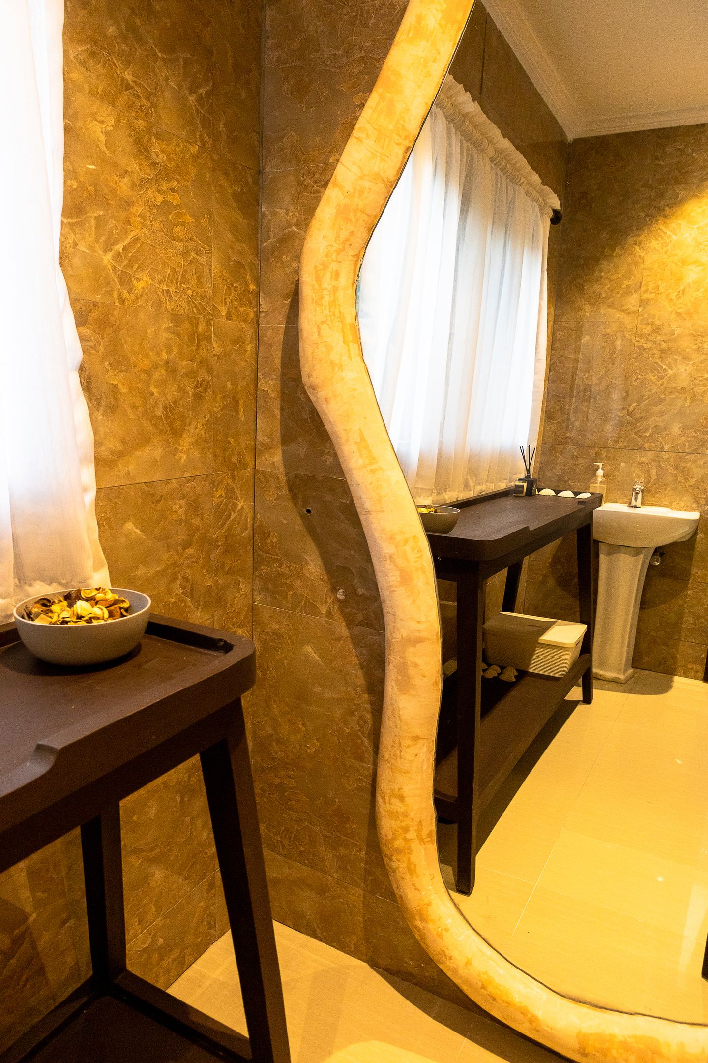 Stone-textured vanity space framed by an organic arch at Emagine