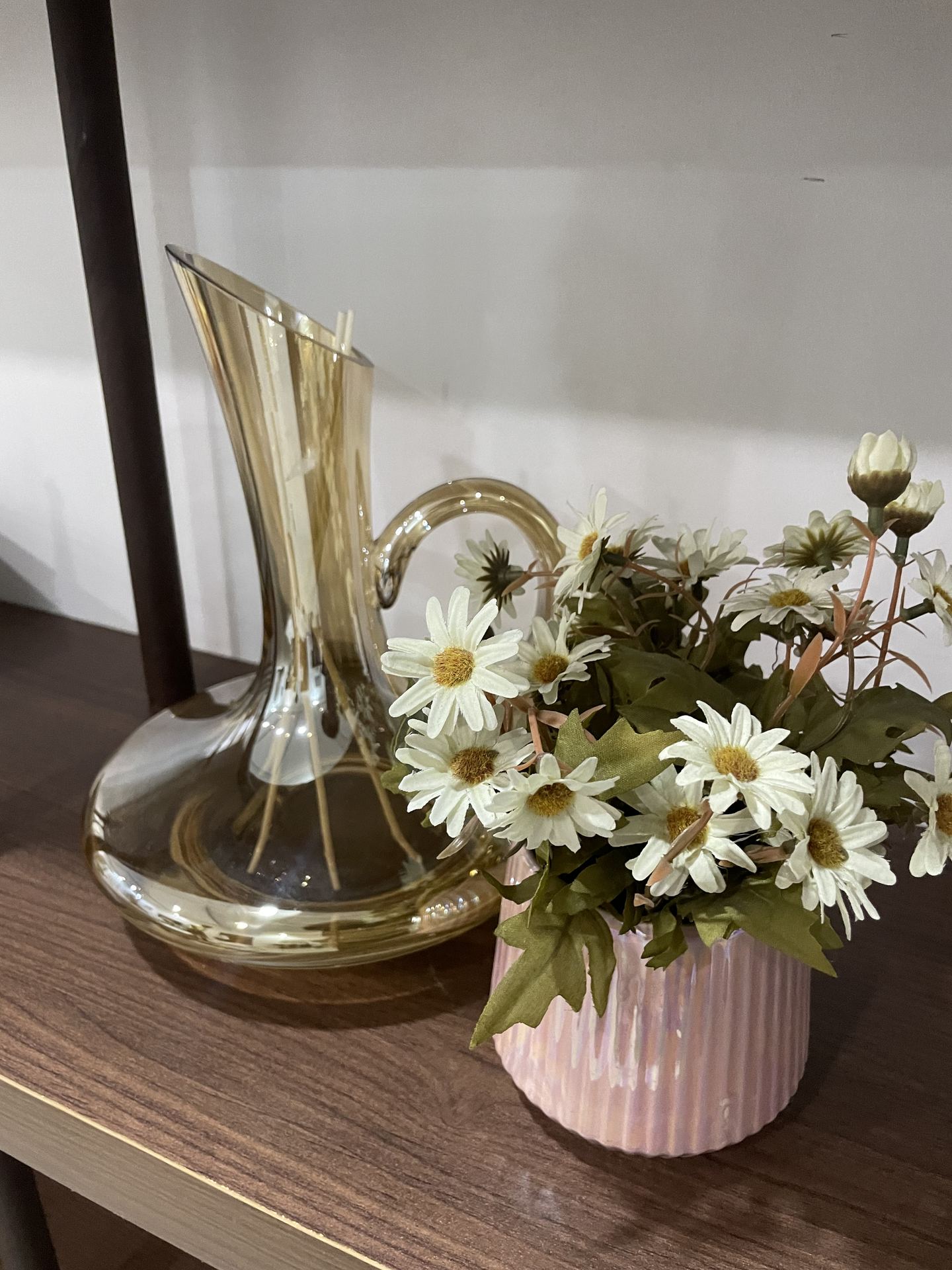 Glass vessel and white flowers styled on a dark console