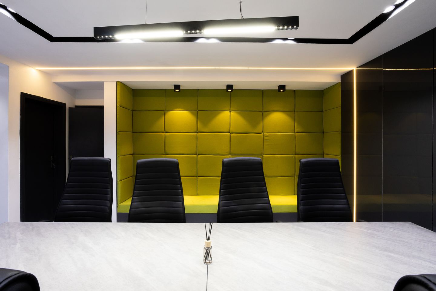 Novac boardroom with olive acoustic wall panels and linear lighting