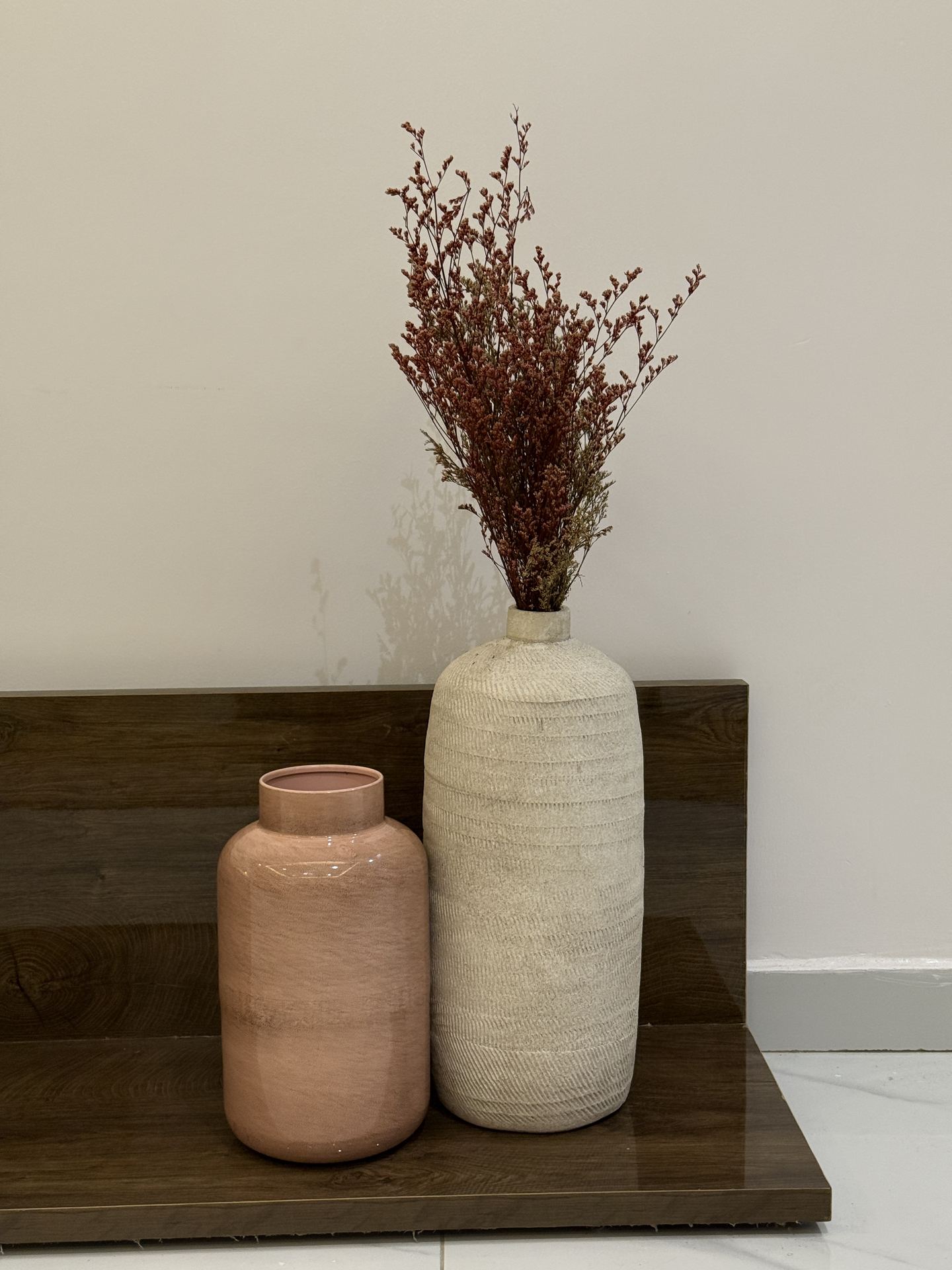 Textured ceramic vessels styled against warm timber