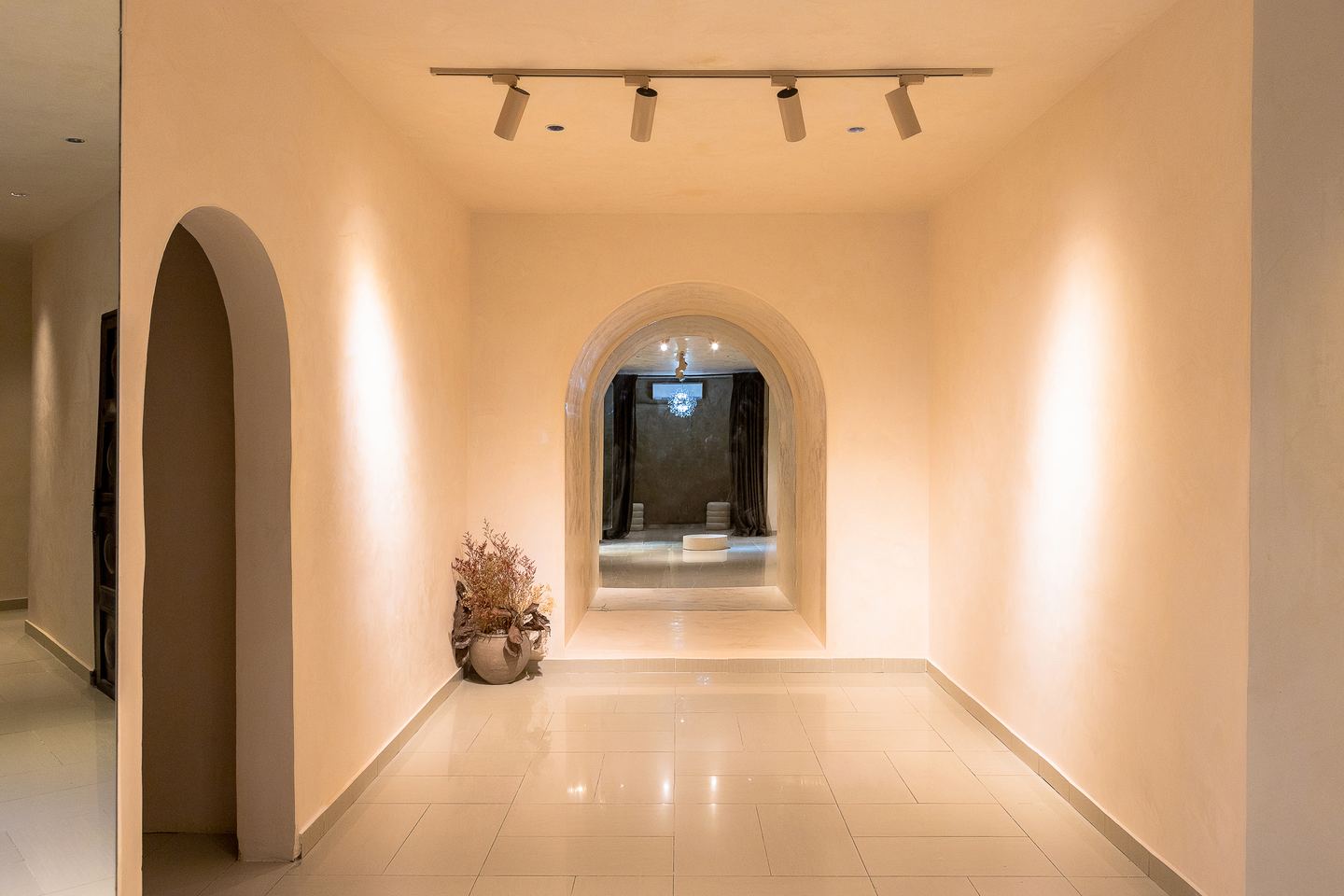 Arched Emagine corridor with layered mirrors and warm spot lighting