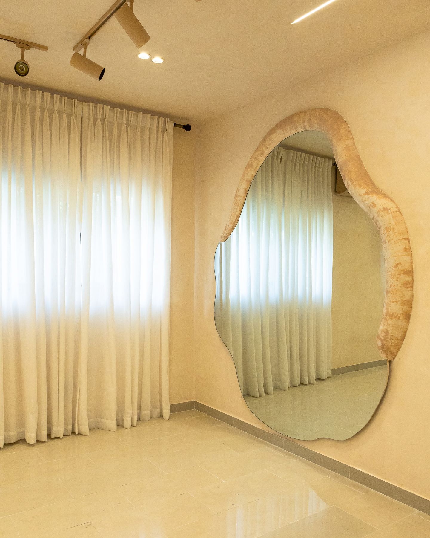 Organic full-height mirror set against softly draped curtains at Emagine