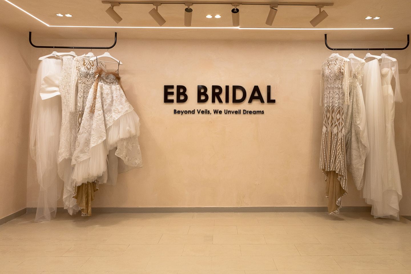 Bridal gowns displayed beside the EB Bridal feature wall
