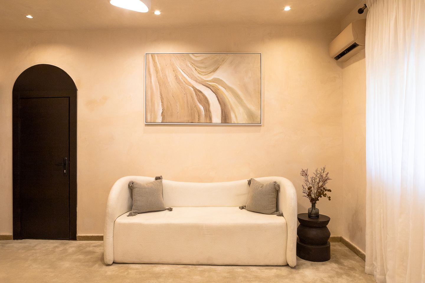 Curved fitting-room sofa beneath abstract artwork at Emagine