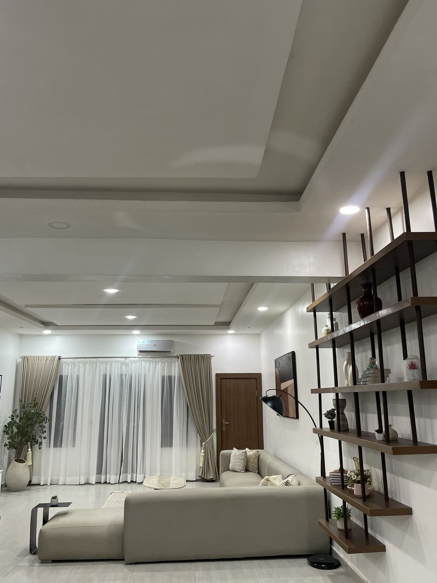 Wide ceiling-line view across the living room and display shelving