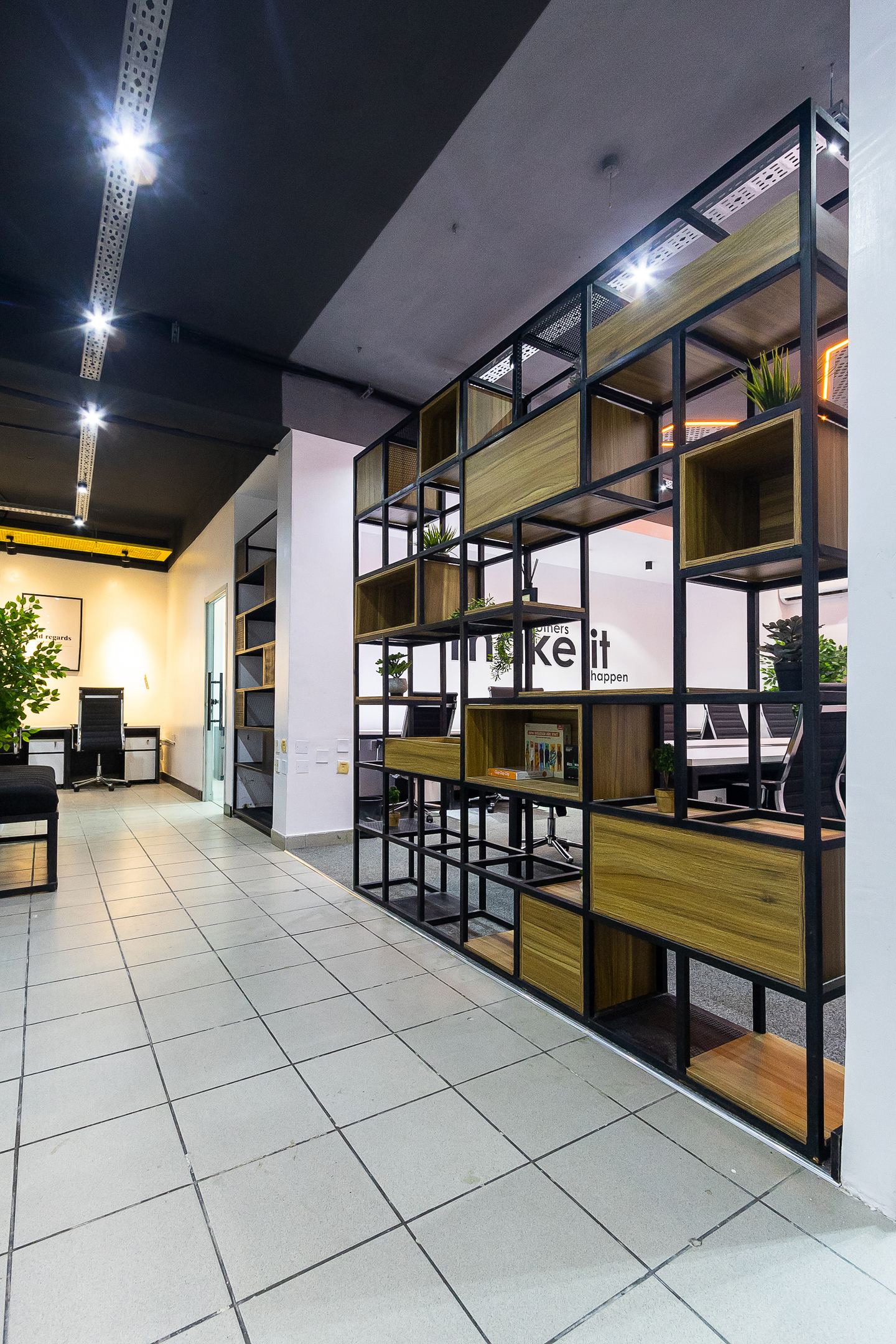 A steel-and-timber shelving screen dividing the work floor