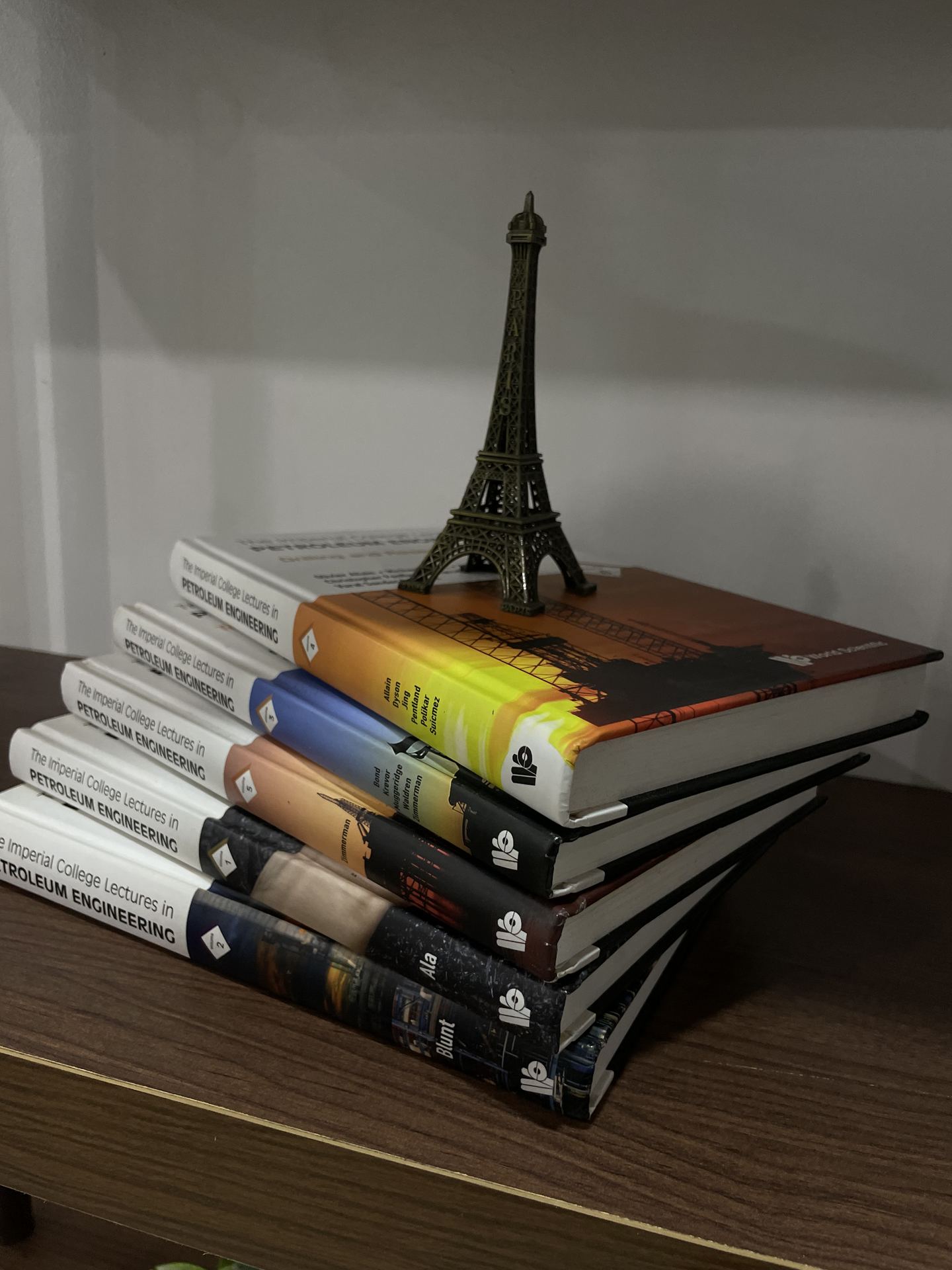 Stack of design books with a small Eiffel Tower sculpture