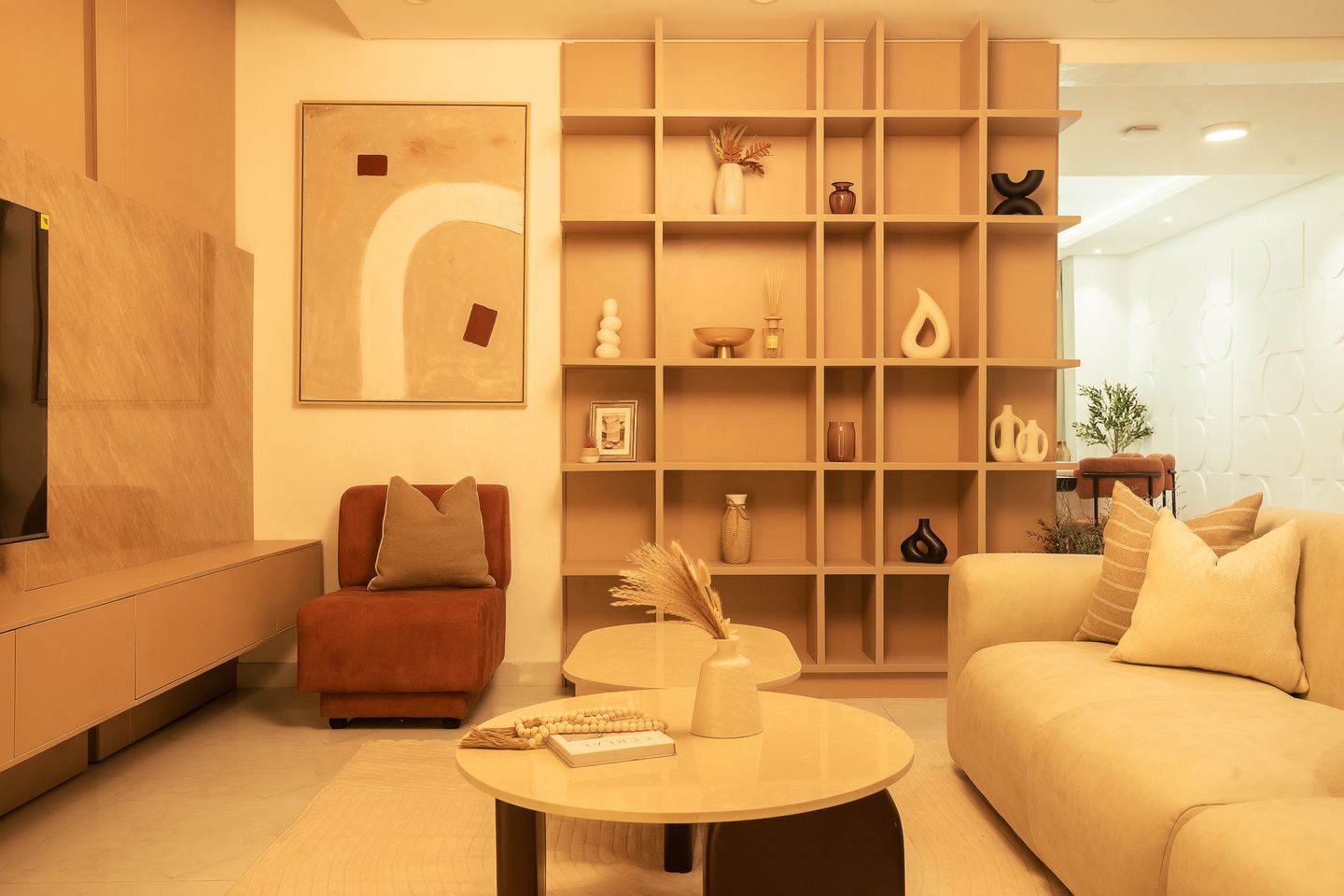 The niche shelving wall, with an armchair and a low round table in front of it