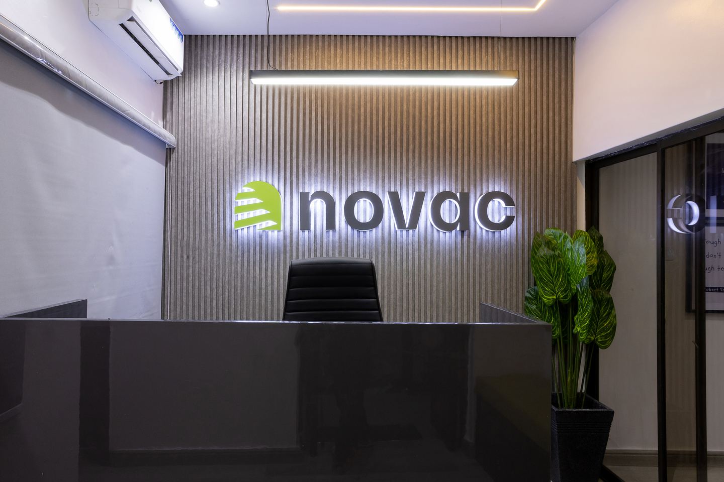 Illuminated Novac reception desk and branded feature wall