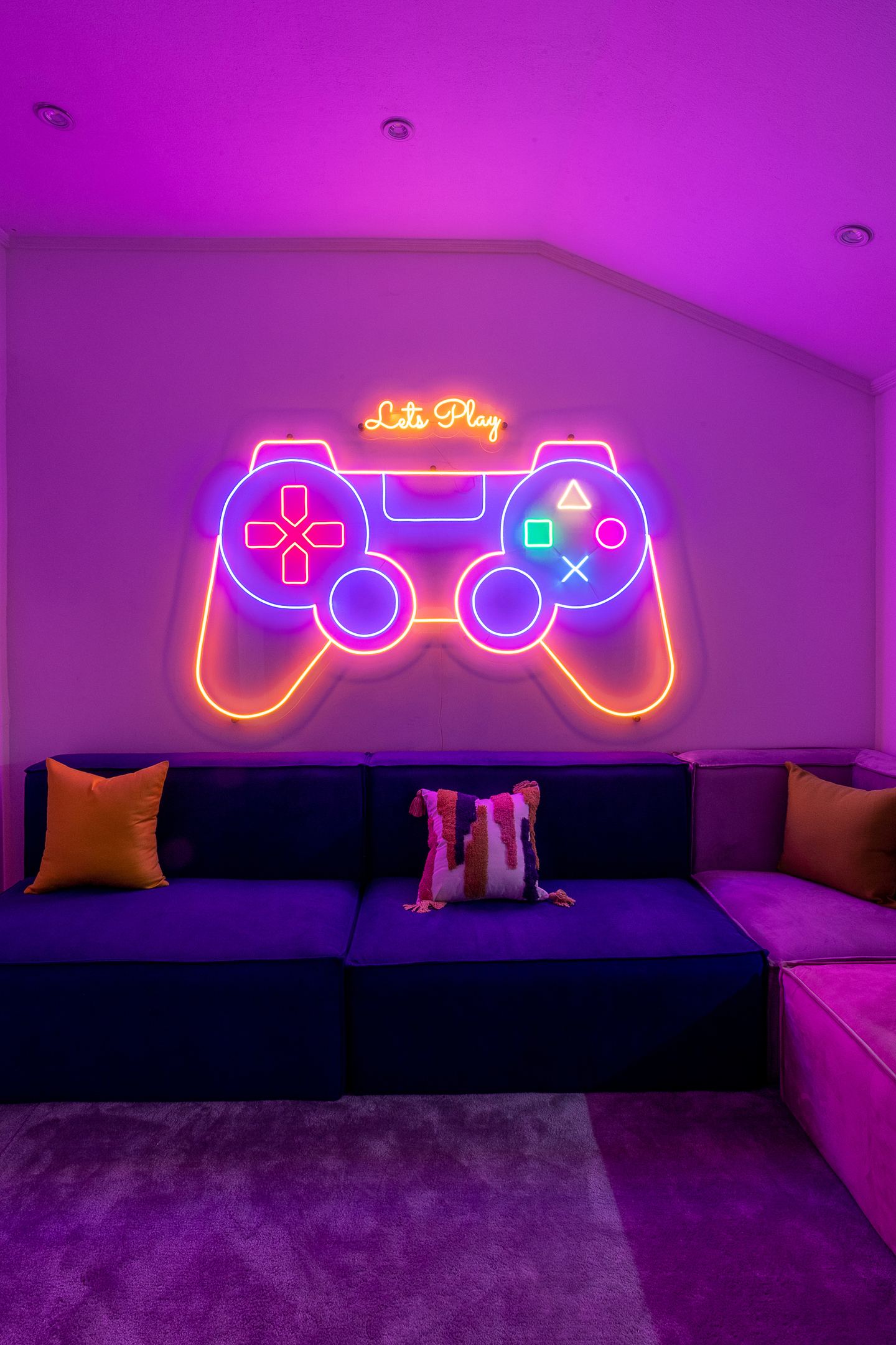 Neon game-controller artwork in the Novac social space